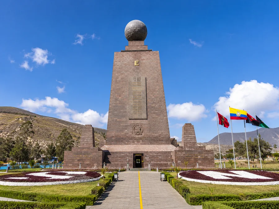 Mitad del Mundo monument with flags in Ecuador.